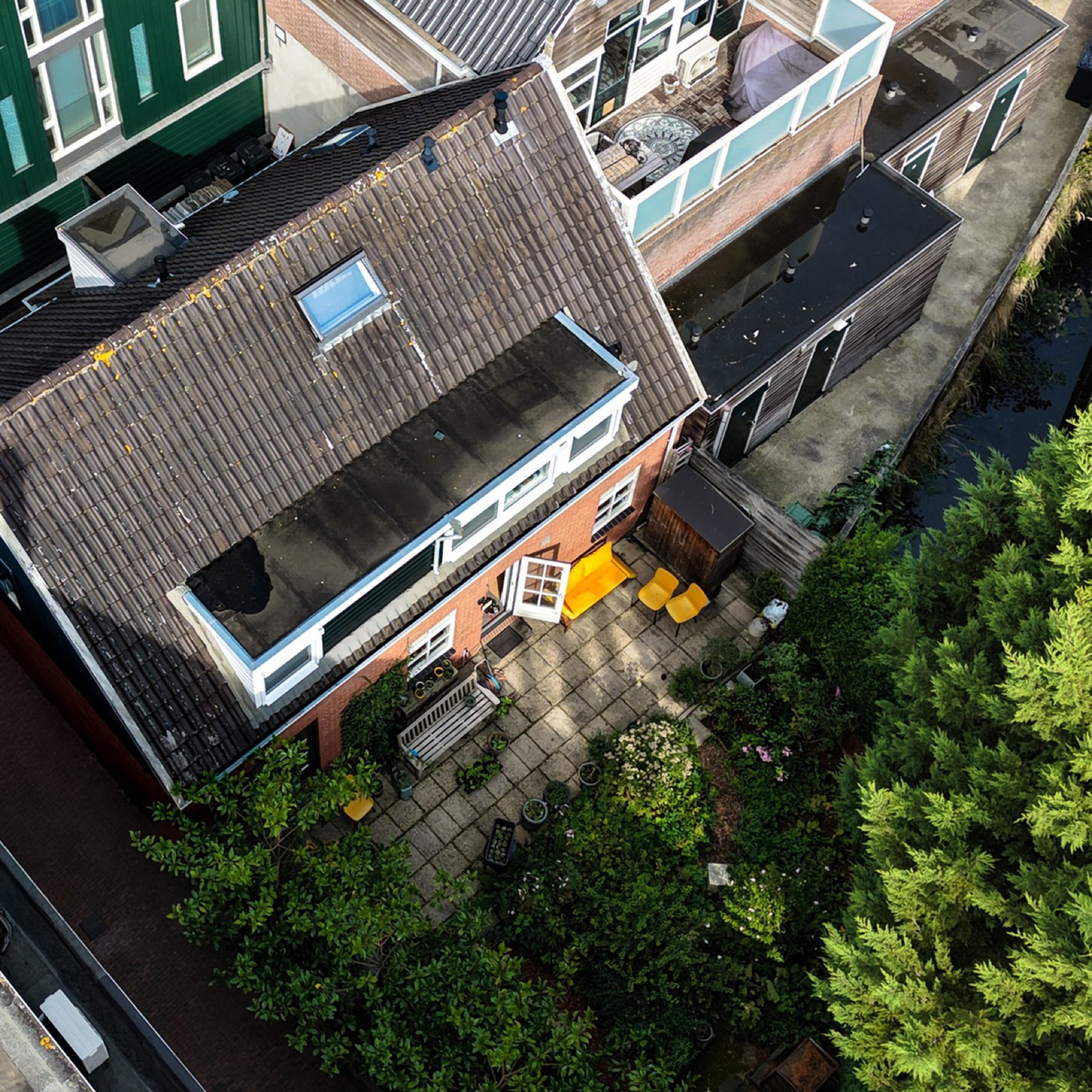 Luchtfoto van huis, terras, tuin en sloot