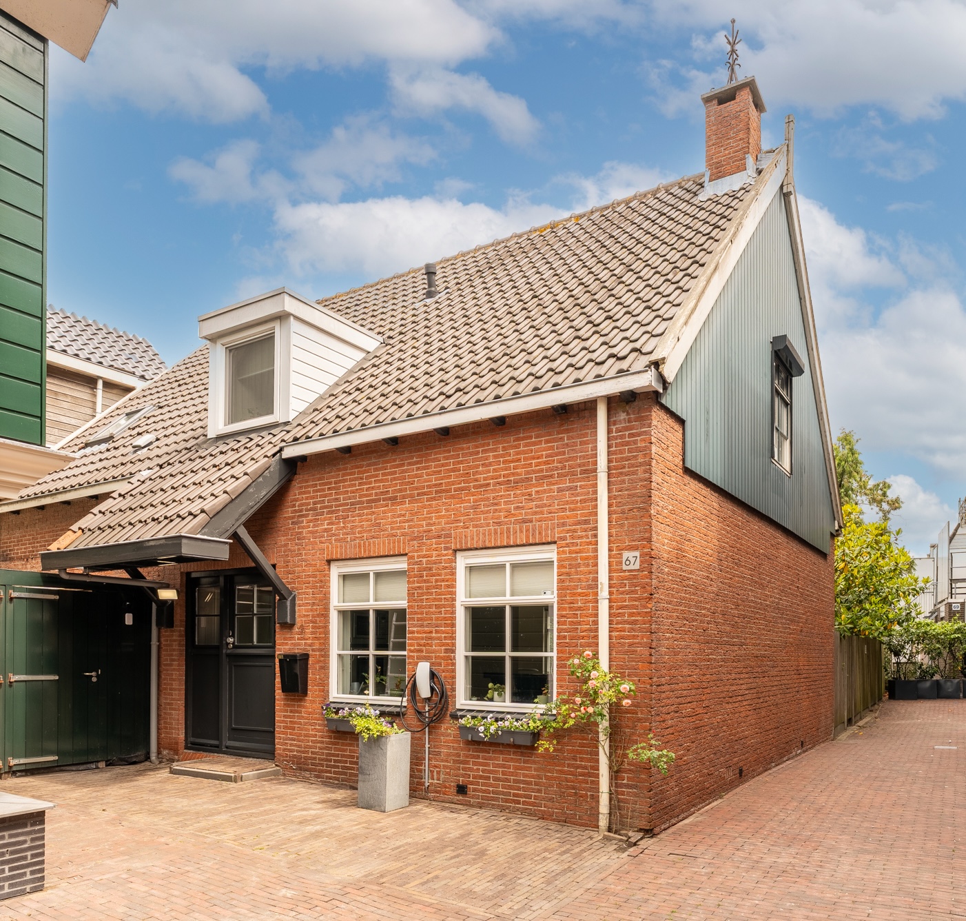 Voorgevel aan de straat, baksteen met huisnummer 67