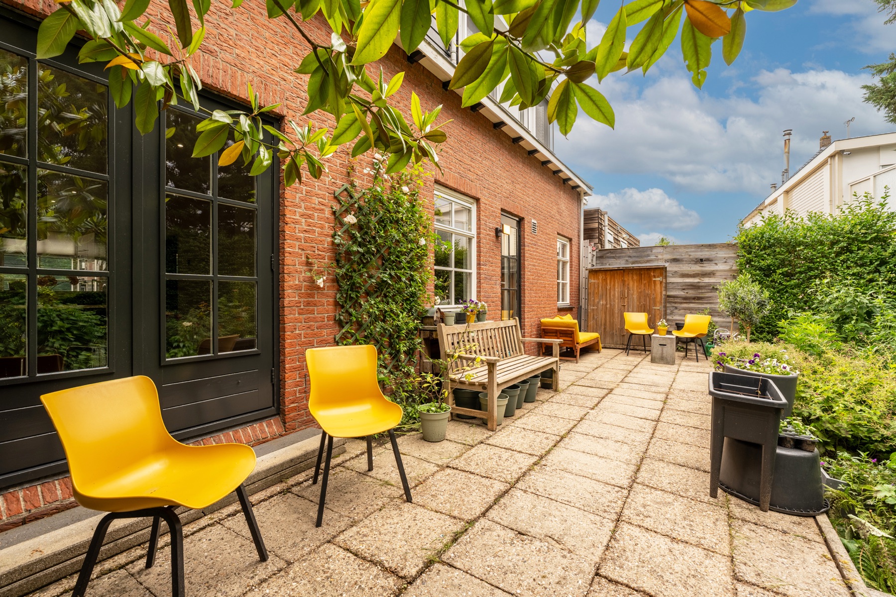 Terras met gele bank tegen de achtergevel